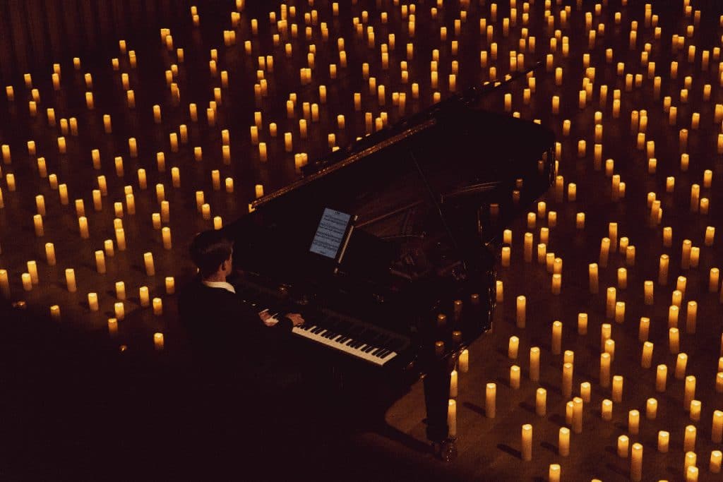 pianista tocando el piano alrededor de velas